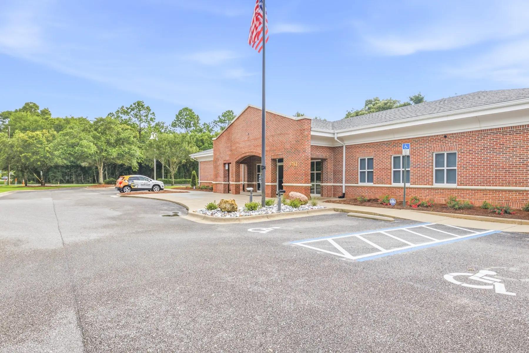 Cadenhead Legacy Center, a single-story brick building, with its parking lot and accessible spaces in Pace, Florida