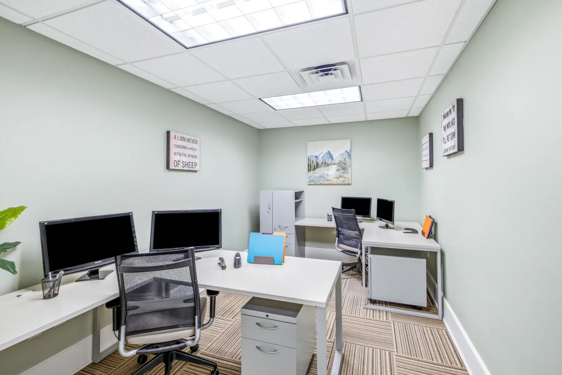 A furnished private office at Cadenhead Legacy Center with desks, monitors and a window